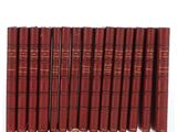 six livres rouges alignés sur une surface blanche