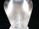 a clear glass vase with a white top on a black surface