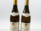 two bottles of wine sitting next to each other on a white surface