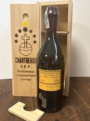 une bouteille de vin dans un coffret en bois, à côté d'un tire-bouchon