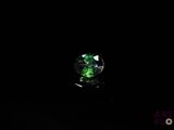 an image of a green crystal sitting on top of a black surface