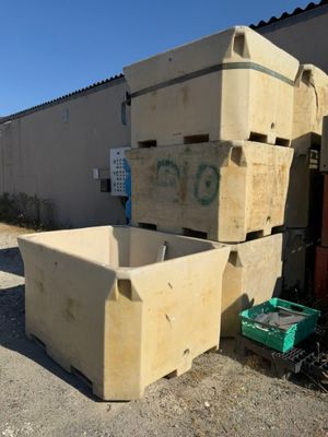 un tas de cartons et de caisses posés devant un bâtiment