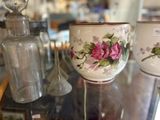two cups on a glass table with a bottle on the side