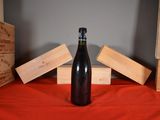 a bottle of wine sitting on a table next to wooden boxes