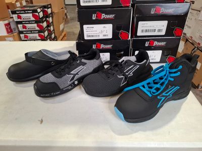 several pairs of black and blue shoes on a table in front of boxes