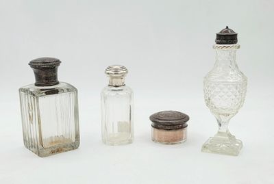 trois bouteilles en verre et une salière en verre posées sur une surface blanche