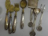 a lot of silver spoons and utensils on the table