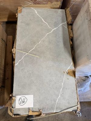 a box of marble on the floor next to a box of wood