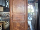 a tall wooden cabinet in a room with a lot of furniture