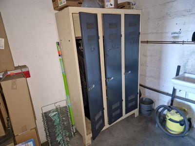two lockers in a room with boxes and a vacuum