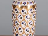 un vase posé sur une table devant un mur gris