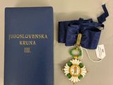 un livre bleu avec, à côté, une médaille d'or et un ruban bleu