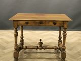 an old wooden table sitting on top of a hard wood floor