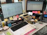 a desk with a computer, keyboard, monitor, and other items on it