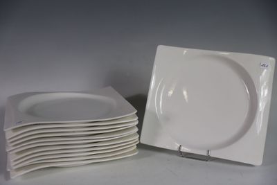 plusieurs assiettes blanches empilées les unes sur les autres sur une table