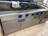 a large stainless steel stove top in a commercial kitchen