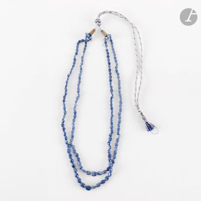 un gros plan sur un collier de perles bleues orné d'un pompon