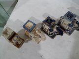 trois petites figurines bleues et blanches assises sur une table