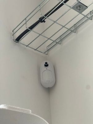 des toilettes dans une salle de bains, avec un panier métallique au-dessus