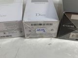three boxes of dior perfume sitting next to each other on a table