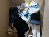 a cardboard box filled with clothes and a skateboard