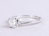 a close up of a diamond ring on a white surface