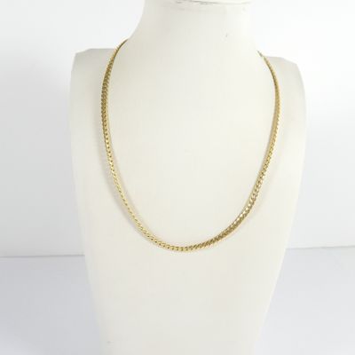 un torse de mannequin blanc orné d'une chaîne en or