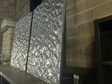 une photo d'un grand écran métallique à l'intérieur d'un bâtiment