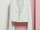 une veste blanche suspendue à un cintre près d'un mur rose