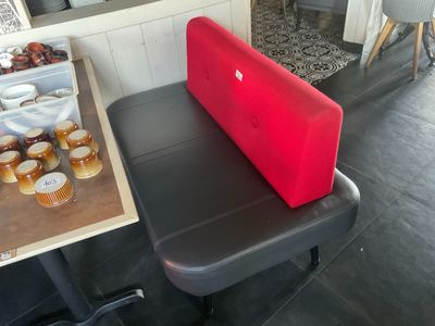 un ordinateur portable rouge posé sur une table noire