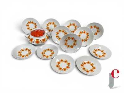 many plates with orange flowers on them on a white surface