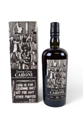 a bottle of caroni with a box of cigarettes next to it