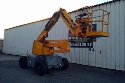 a picture of a yellow cherry picker parked in front of a building