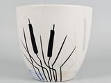 a white cup with black cattails on it