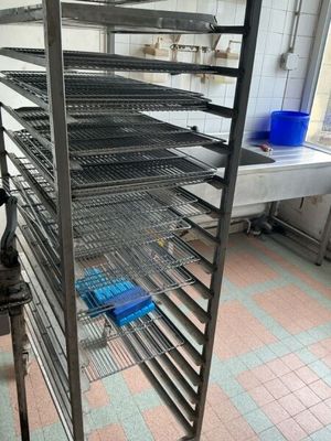 a large metal rack in a kitchen with blue bins
