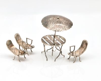 three chairs and a table with an umbrella on it