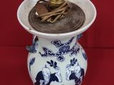 un vase bleu et blanc contenant des pièces de monnaie, sur fond rouge