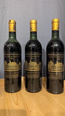 three bottles of wine are lined up on a wooden table