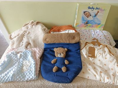 a teddy bear sitting on a bed next to other items