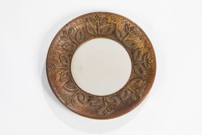 a mirror on the wall with a decorative design on it