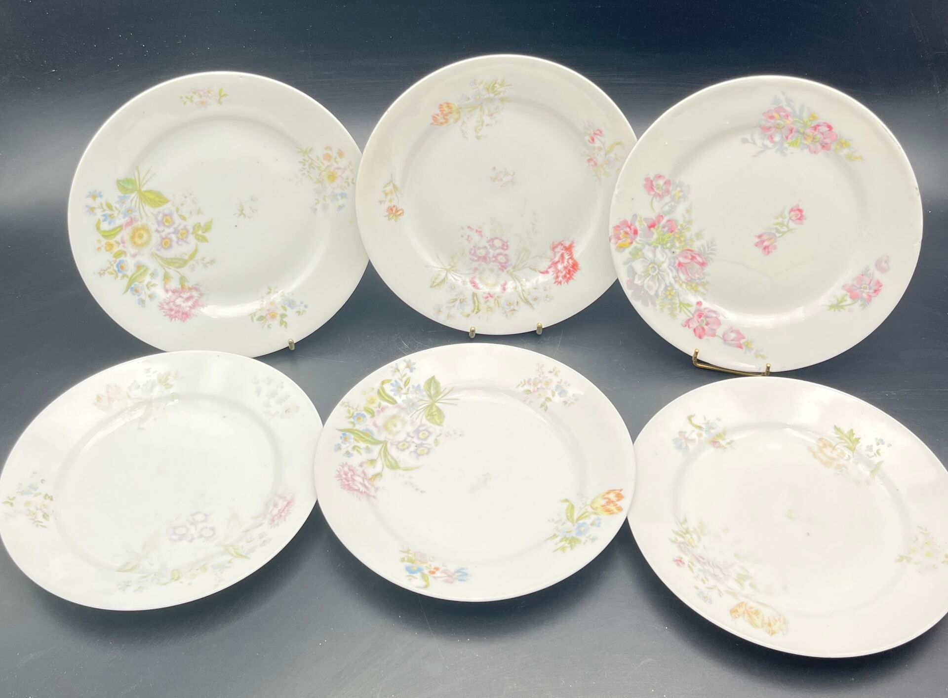 Six petites assiettes à dessert en porcelaine à décor polychrome floral. (fêles)