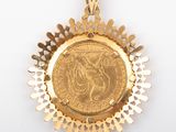 a close up of a coin in a gold pendant on a white background
