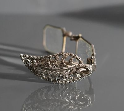 une photo en gros plan d'un bracelet en argent posé sur une table