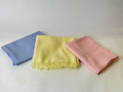 three different colors of towels on a white surface