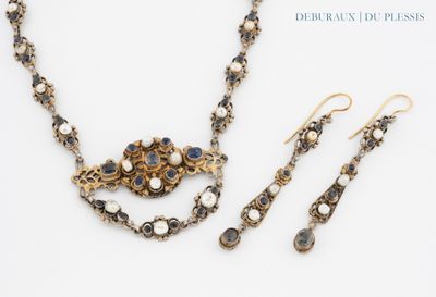 a close up of a necklace and earring set on a white surface