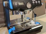 a coffee machine sitting on a table next to a bottle of soda