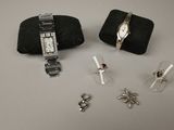 deux montres et une paire de boucles d'oreilles posées sur une table