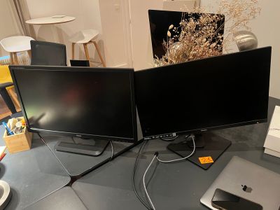 two computer monitors sitting on a table next to a laptop