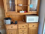 a wooden cabinet with a microwave on top of it