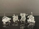 cinq figurines d'animaux en verre transparent posées sur une table